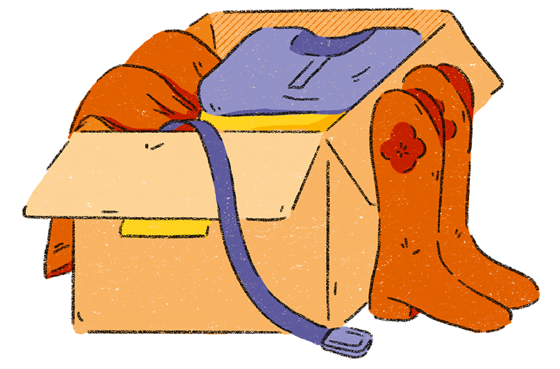 There is an open brown cardboard box filled with clothes. A pair of orange cowboy boots sit next to the box and a purple belt is hanging out the box too.