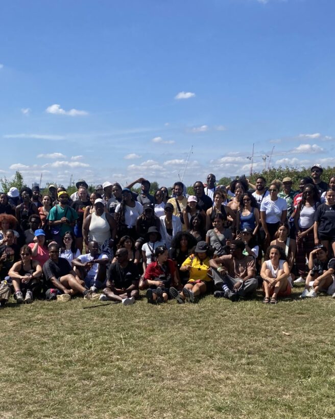 the picture shows a group of people in a park posing in a group together for the photo