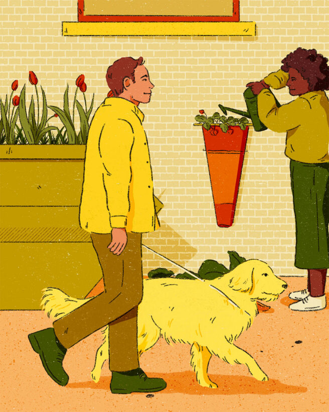 The image shows a big yellow skip which has been turned into a flower bed. There are lots of plants and flowers poking out the top. Next to the skip are two people tending to plants and in the foreground there is a person walking past with a yellow dog.